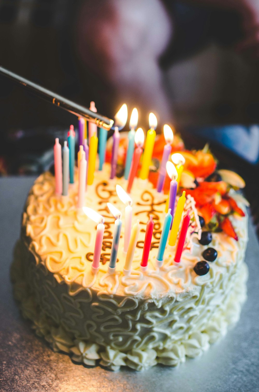 Bolo de aniversário com muitas velinhas coloridas acesas