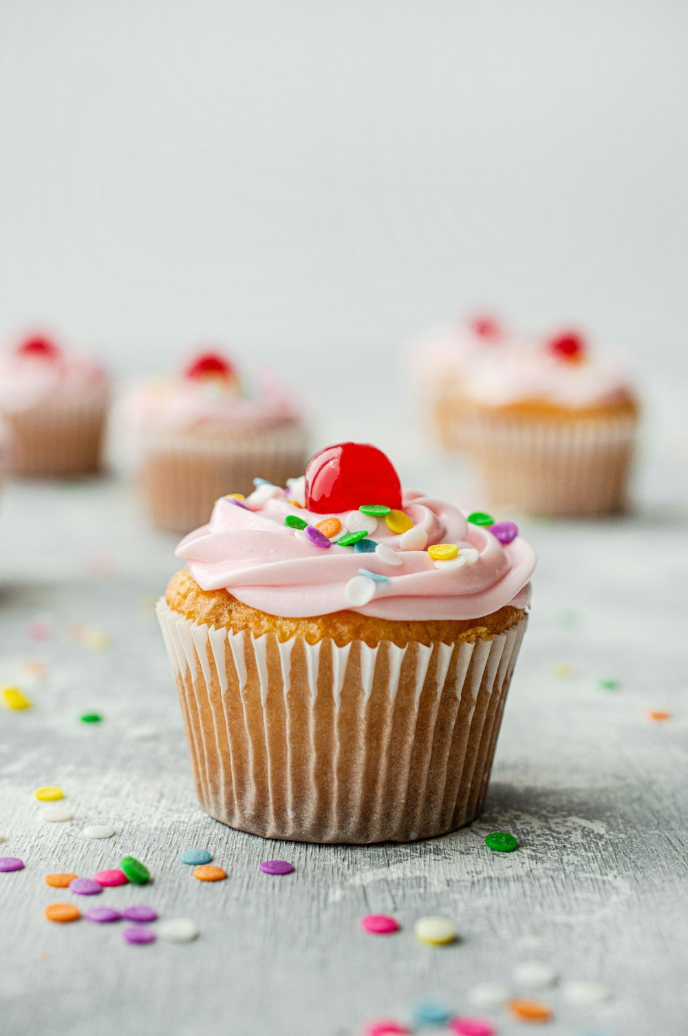 Cupcake com morango e confeitos coloridos