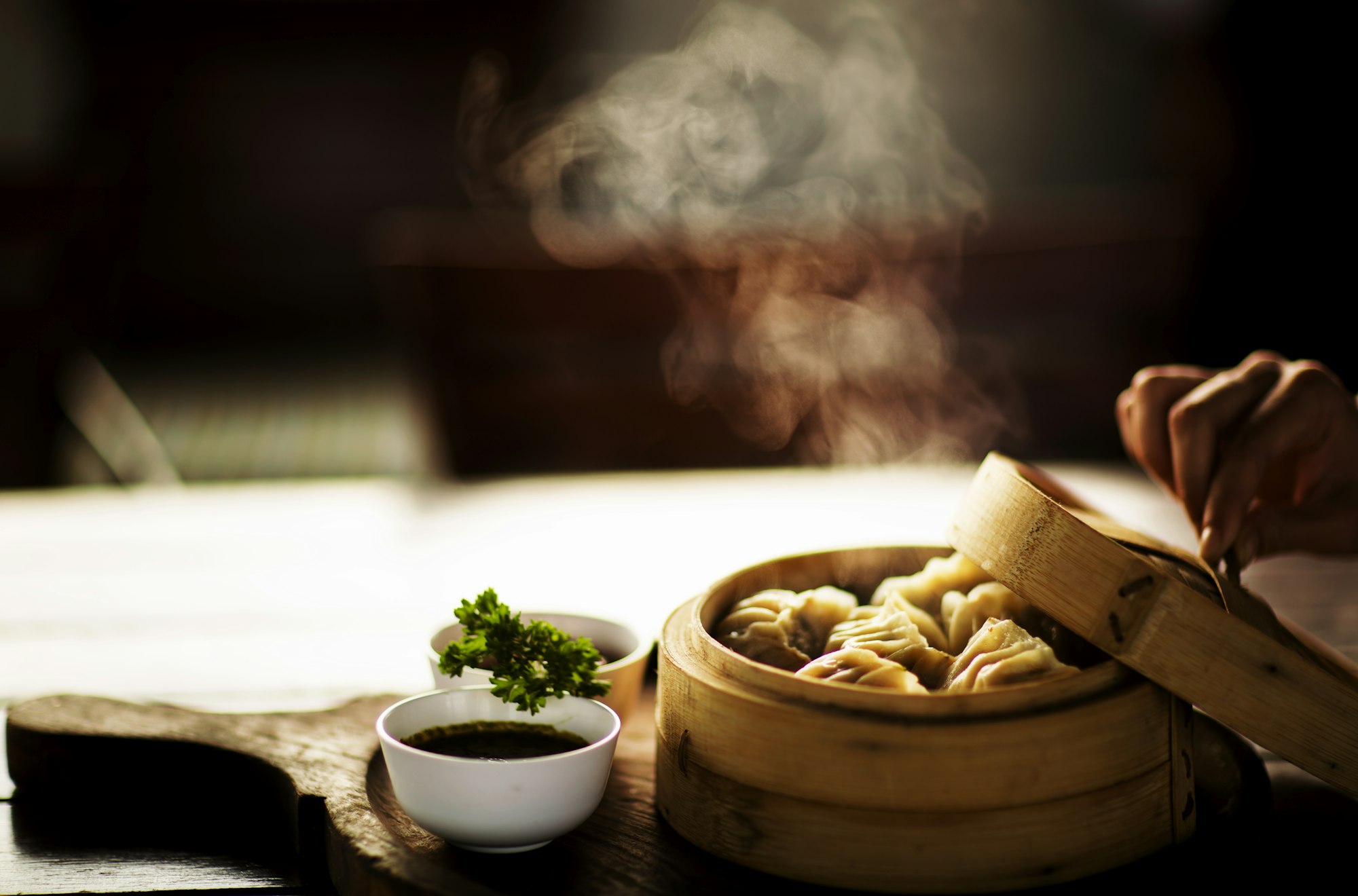 Vapor subindo de um cesto de bambu com dim sum recém-preparado