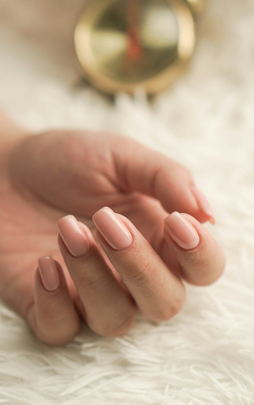 Mãos com manicure nude e acabamento natural